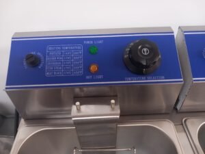 Close-up view of the precise temperature controls on a Commercial Double Fryer, featuring adjustable heat settings for accurate frying in professional kitchens.