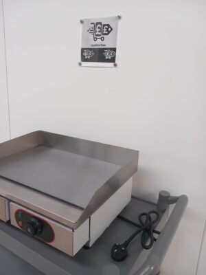 Right side view of a 55cm commercial griddle, featuring a flat cooking plate, precise temperature controls, and the sturdy stainless steel build ideal for professional kitchens.