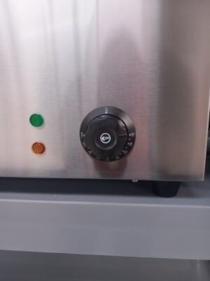 Close-up of the temperature control panel on a commercial 3-pot bain marie, showing adjustable heat settings and indicator lights for precise temperature regulation in professional food service.