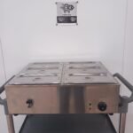 Front view of a commercial 6-pot bain marie with all lids on, featuring the user-friendly temperature controls and accessible water drainage tap for hassle-free operation in commercial kitchens.