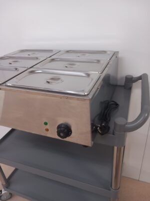 Lower right-angled view of a commercial 6-pot bain marie with lids in place, focusing on the easy-to-use temperature controls and power indicator lights designed for precise food warming.