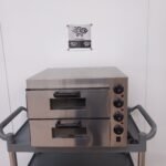 Front view of a Twin Deck Commercial Pizza Oven with both doors closed, showing durable stainless steel construction and temperature controls on the right side for efficient operation in commercial kitchens.