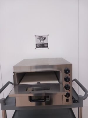 Front view of a Twin Deck Commercial Pizza Oven with the top oven door open, revealing the stone base inside for authentic pizza baking, with temperature controls on the right for precise heat adjustment.