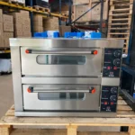 Front view of a large commercial pizza oven with dual doors closed and temperature controls visible on the right, featuring durable stainless steel construction and precise heat management for professional kitchens.