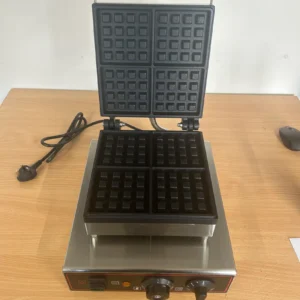 Square Commercial Waffle Maker with lid open, showing non-stick waffle plates and 1.6kw power plug on the left. Ideal for cafes and restaurants, this durable appliance ensures perfect waffle results with even heat distribution.