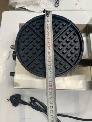 Image showing the bottom plate of the Commercial Waffle Maker with a tape measure indicating compact dimensions of 250 x 340 x 200mm, perfect for space-saving in professional kitchens.