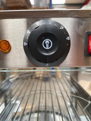 Close-up view of the temperature control dial on a curved heated display, offering precise temperature regulation for maintaining optimal food warmth in commercial foodservice operations.